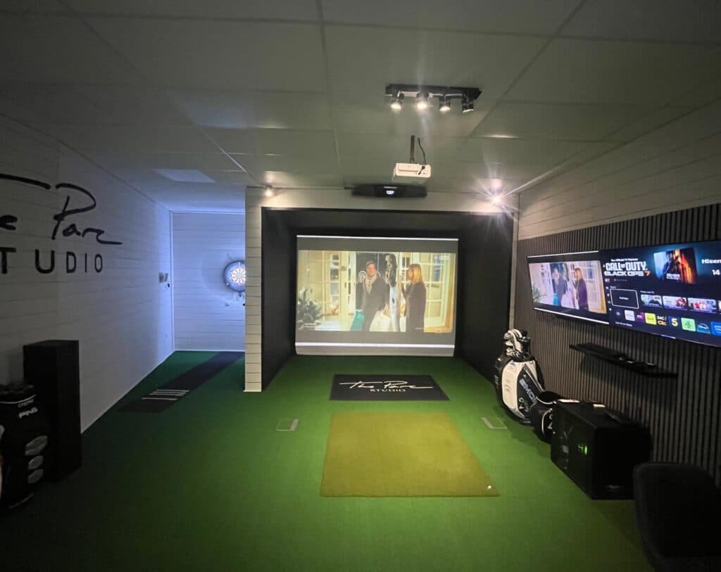 Indoor golf simulator room setup built using insulated steel building kit